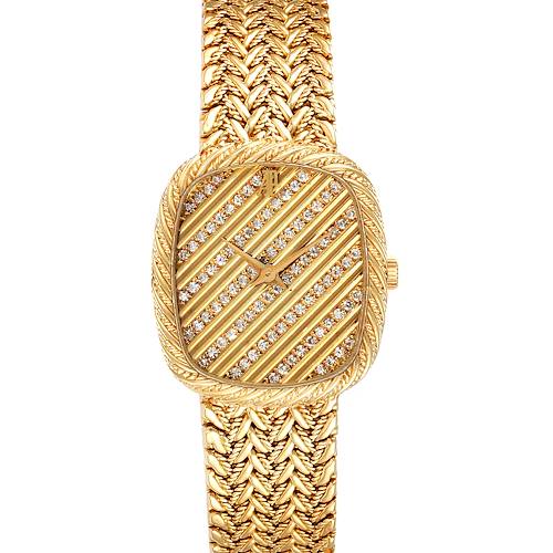 The Audemars Piguet Vintage Women's Yellow Gold Champagne Dial watch is shown from a top-down angle, featuring a detailed face with gem settings and a woven bracelet.