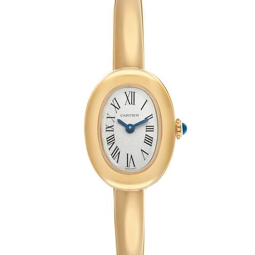The Cartier Baignoire WGBA0044 Women's Yellow Gold Silver Dial watch is shown from a top-down angle, displaying its oval face, Roman numerals, and gold bracelet.